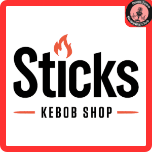 The logo for "Sticks Kebob Shop" features the word "Sticks" in large black letters with an orange flame accenting the letter "i." Below, in smaller black letters, is "Kebob Shop," flanked by two orange lines. The entire design is framed by a thick red border that includes a crest in the top right corner. Product Name: Sticks Kebob Shop $15